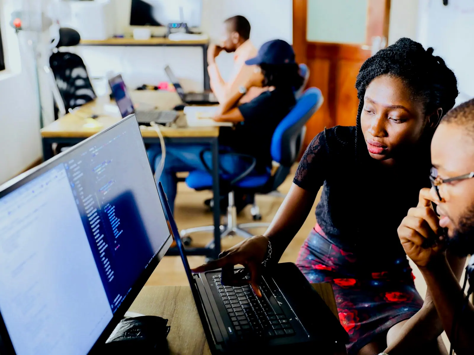 Two engineers reviewing code together at a workstation